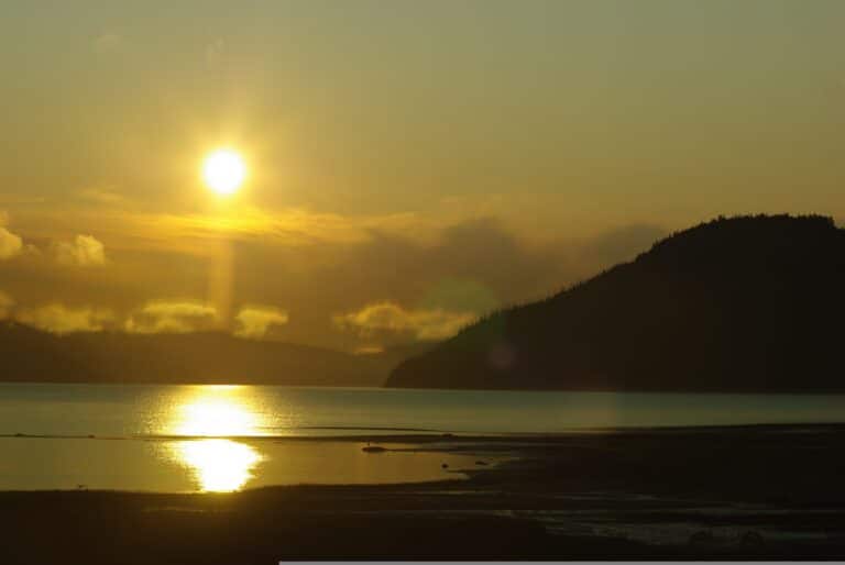 Abendlicher Blick vom Ufer aus auf den goldenen Sonnenuntergang über dem Lac Saint Jean in Quebec